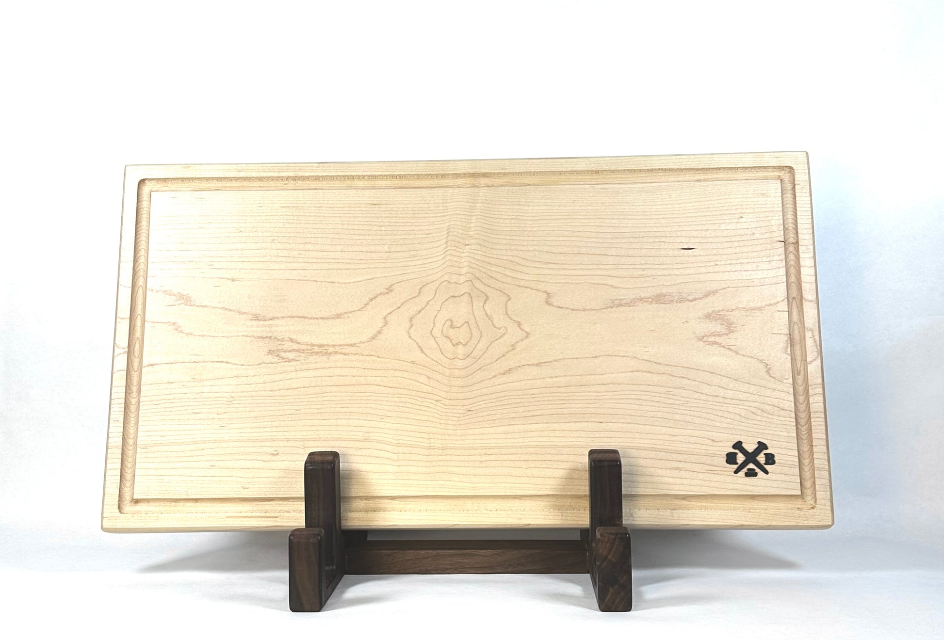 Wooden cutting board on a stand with a visible brand logo against a white background