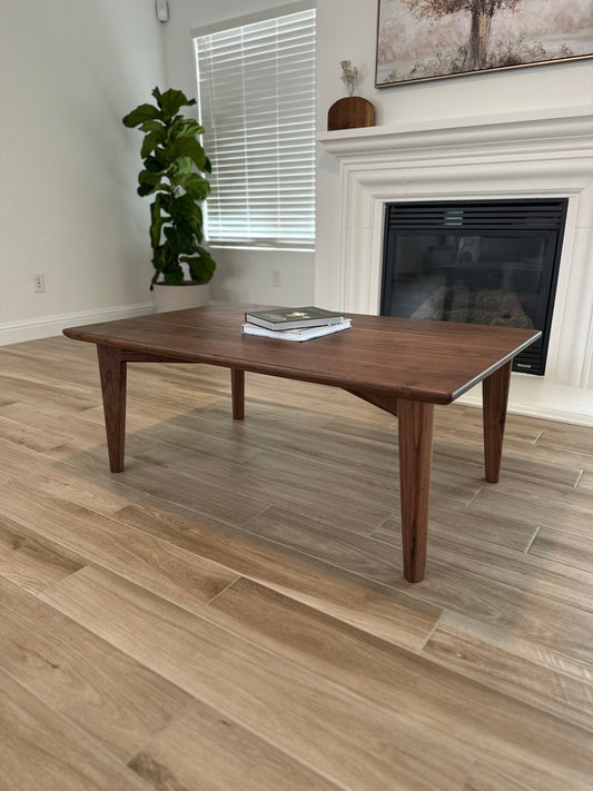 Bonobuilt Cove Coffee Table in solid walnut, 48×30×18 in, Scandinavian-inspired design, staged in a living room — handcrafted in Visalia, California
